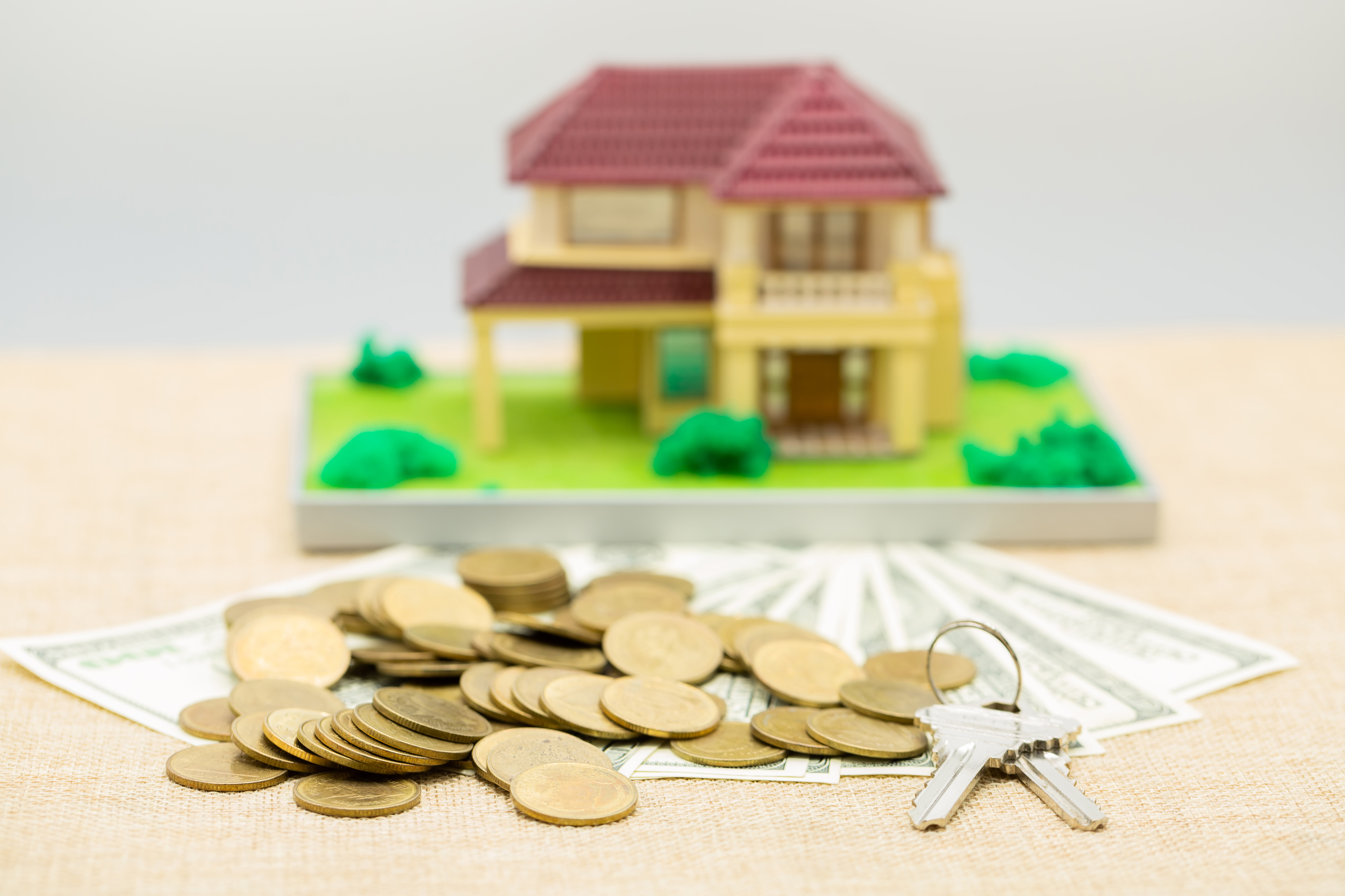 Home equity loan and HELOC financing represented by a house, cash, and keys